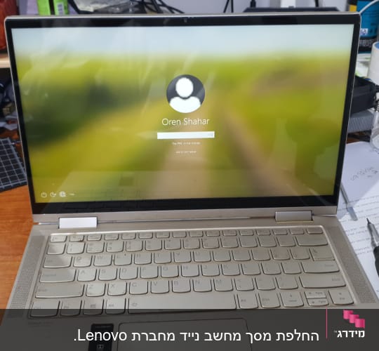 מחשב נייד פתוח עם מסך כניסה, כלים טכניים על השולחן